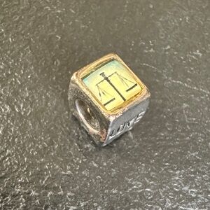 Silver and Enamel Scales of Justice charm.